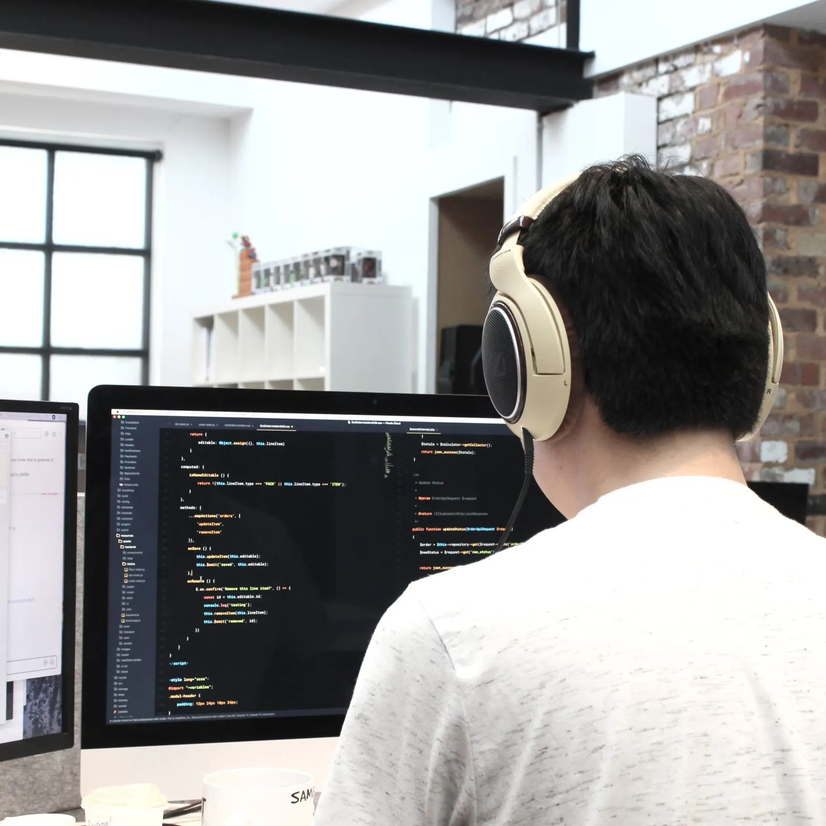 Designer wearing headphones, working at a desk