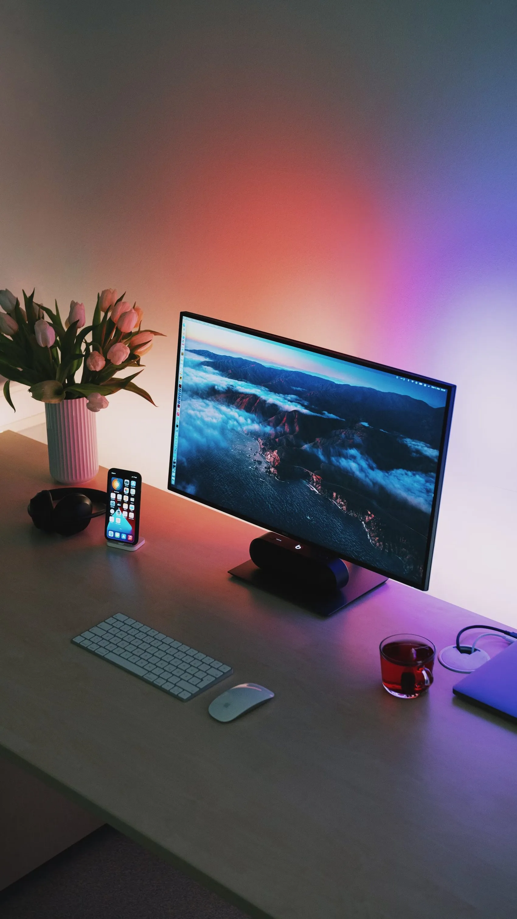 Desk with a phone, a keyboard and tulips in warm light